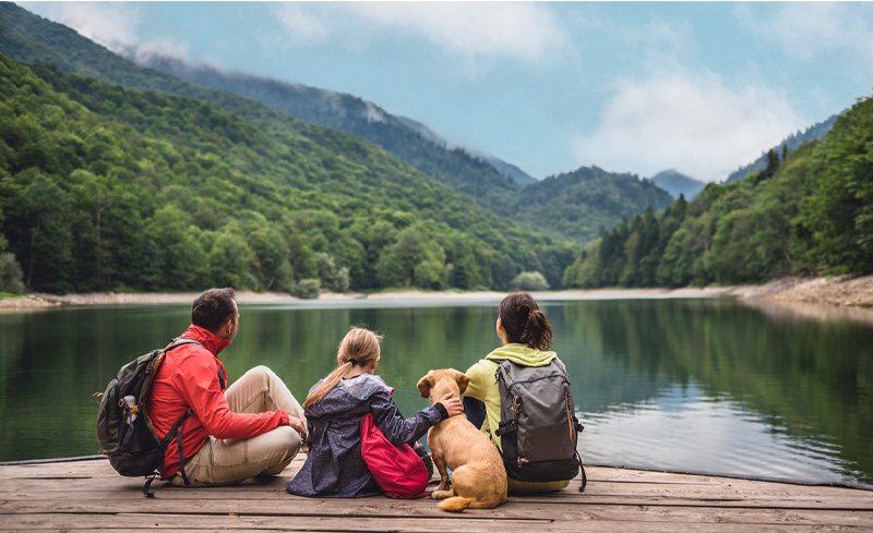 Family with a dog on pier by lake