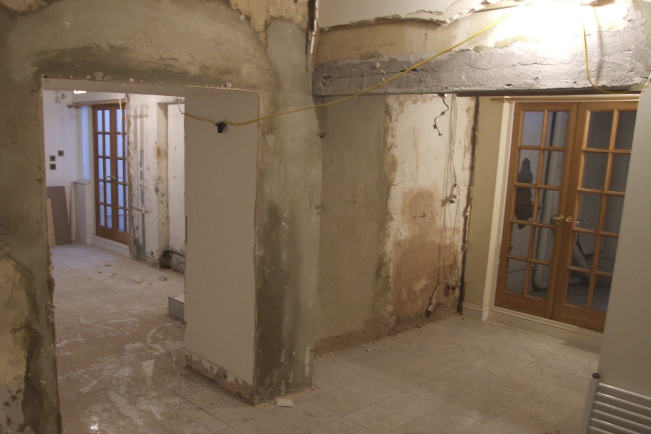 A bare room with with exposed walls, floors and wiring.