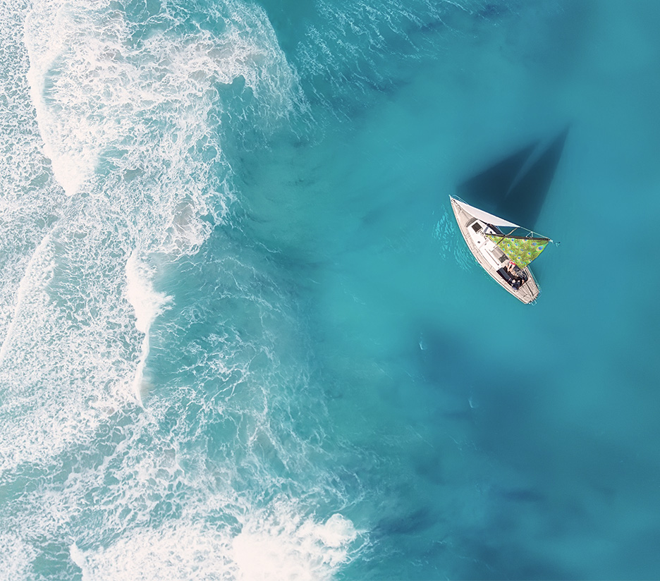 Birdseye view of sailing boat with peacock sail