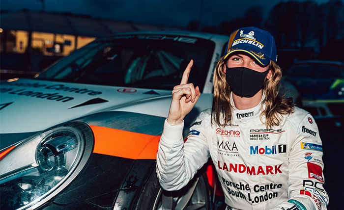 Esmee Hawkey in racing gear in front of her car