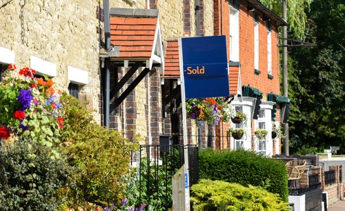 House for sale sign reading sold by estate agent or real estate letting