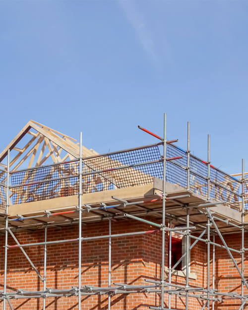 The roof of a house under construction against a blue sky