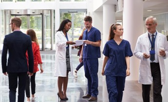 Staff In Busy Lobby Area Of Modern Hospital