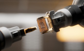 An automated robotic arm is gripping a CPU inside of a circuit board factory.