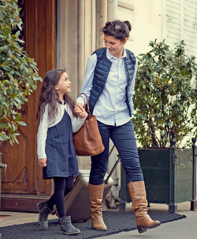 Mother and daughter leaving for a trip with suitcase